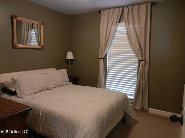 bedroom with carpet, multiple windows, and baseboards