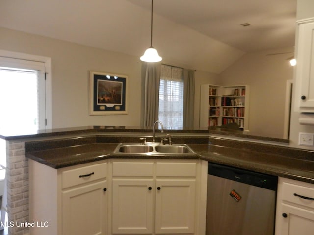 kitchen featuring white cabinets, hanging light fixtures, vaulted ceiling, stainless steel dishwasher, and a sink