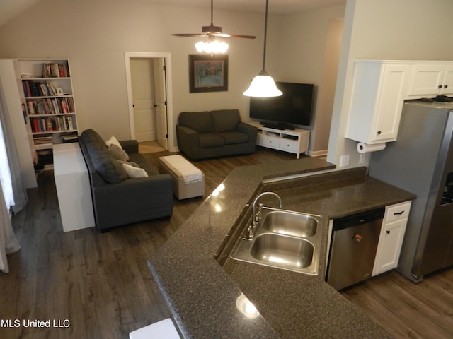 kitchen featuring white cabinets, appliances with stainless steel finishes, open floor plan, dark wood-type flooring, and a sink