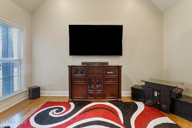 living room with light hardwood / wood-style floors and vaulted ceiling