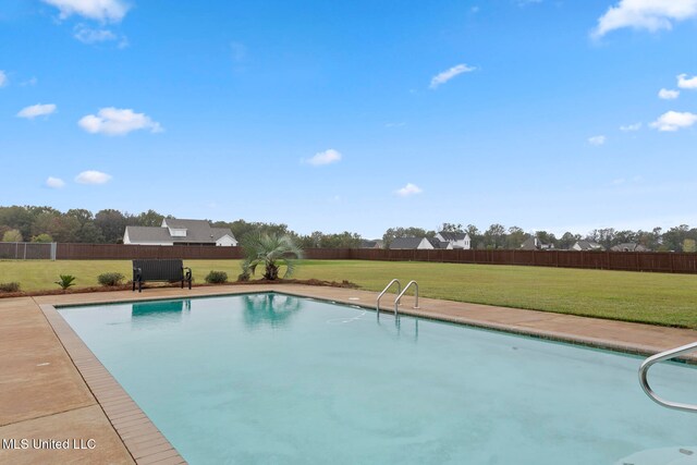 view of pool featuring a patio and a yard