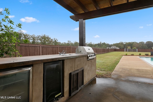 view of patio with a fenced in pool, exterior kitchen, wine cooler, and a grill