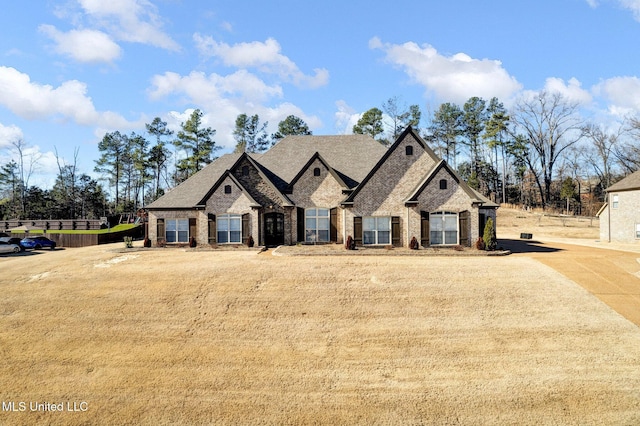 french country inspired facade featuring a front yard