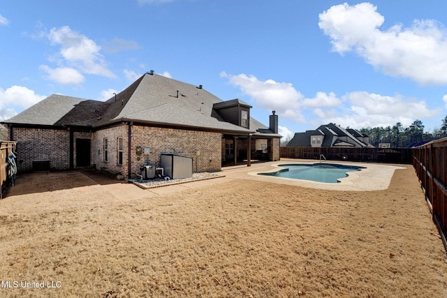 back of property featuring a fenced in pool and a patio area