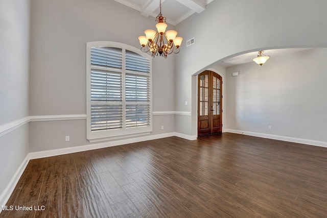 unfurnished room with beam ceiling, dark hardwood / wood-style floors, and an inviting chandelier