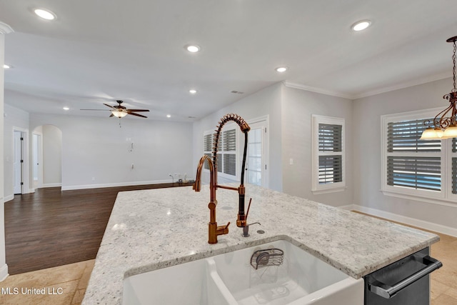 kitchen with dishwasher, sink, decorative light fixtures, ceiling fan, and light stone counters