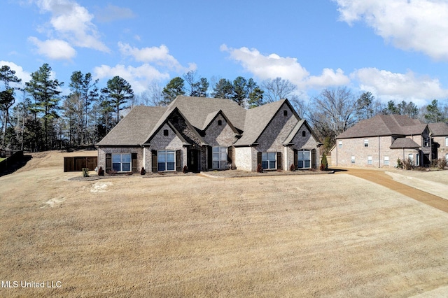 french provincial home with a front yard