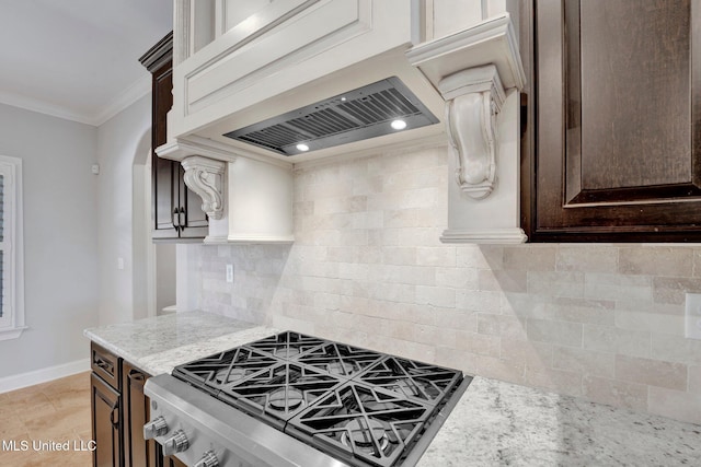 kitchen featuring custom exhaust hood, crown molding, tasteful backsplash, gas stove, and light stone counters