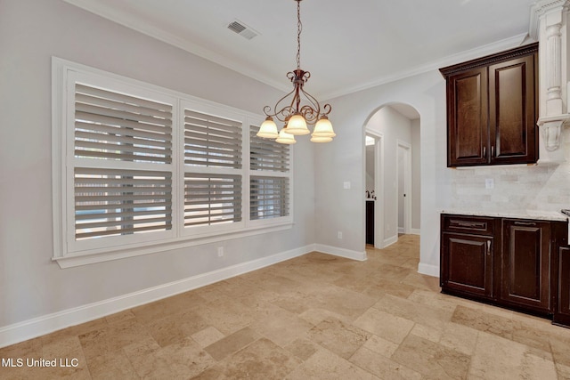 unfurnished dining area with crown molding and an inviting chandelier