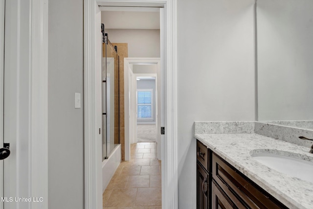 bathroom featuring bath / shower combo with glass door, tile patterned floors, and vanity