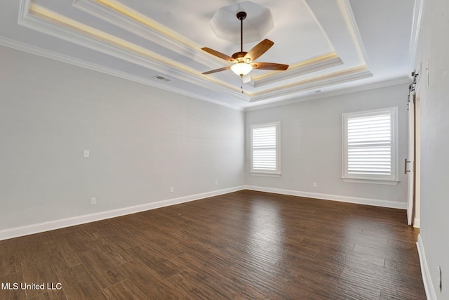 spare room with ceiling fan, ornamental molding, dark hardwood / wood-style flooring, and a tray ceiling