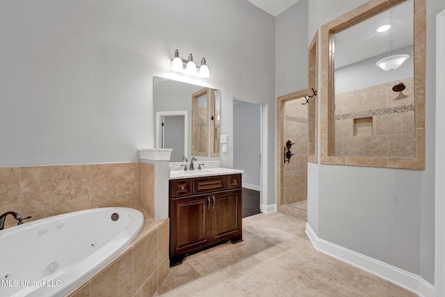 bathroom with vanity and shower with separate bathtub