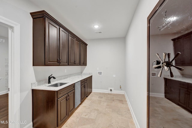 clothes washing area with sink, hookup for an electric dryer, cabinets, and washer hookup