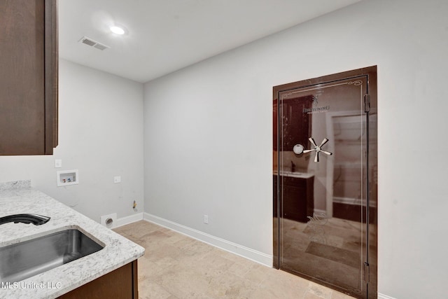 clothes washing area with sink, electric dryer hookup, cabinets, and washer hookup