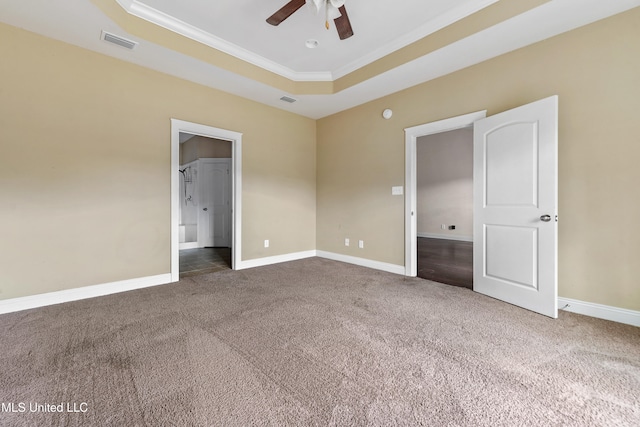 unfurnished bedroom with crown molding, carpet floors, a tray ceiling, and ceiling fan