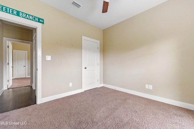 carpeted spare room featuring ceiling fan