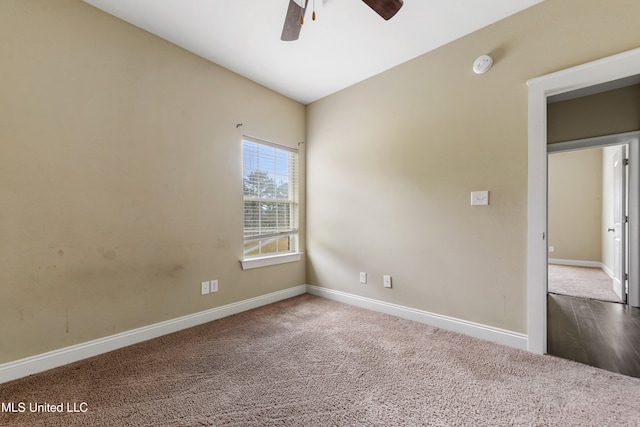 spare room featuring vaulted ceiling, carpet flooring, and ceiling fan