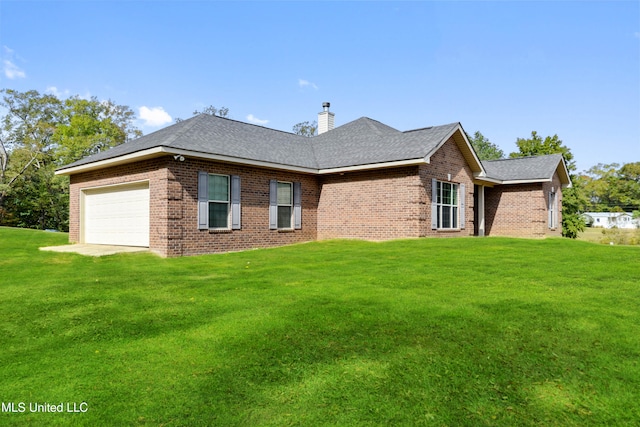 rear view of property featuring a yard and a garage