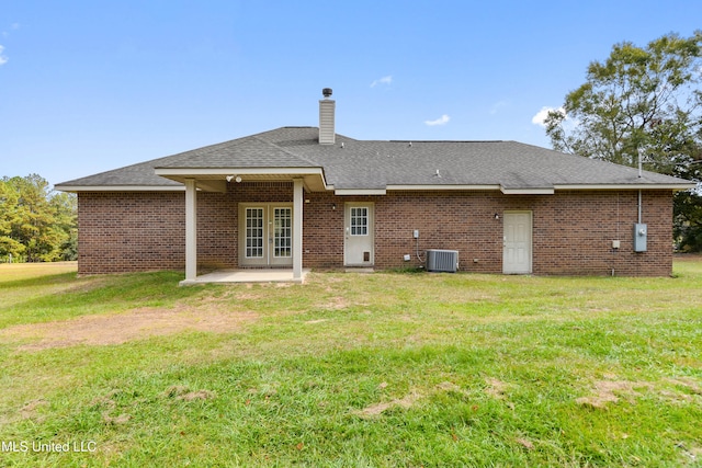 rear view of property featuring central air condition unit, a patio area, french doors, and a yard