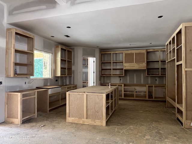 517 Central Cir, Brandon, MS 39047 - kitchen with open shelves, a kitchen island, and light brown cabinetry
