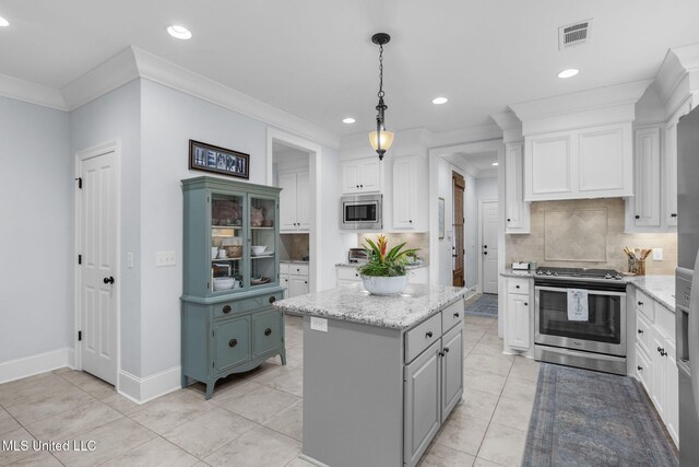 308 W Park St, Canton, MS 39046 - kitchen featuring appliances with stainless steel finishes, recessed lighting, tasteful backsplash, a kitchen island, and light stone countertops