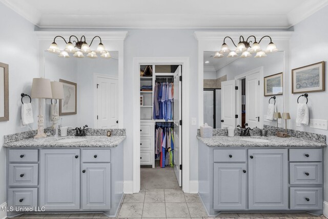308 W Park St, Canton, MS 39046 - full bath featuring a chandelier, ornamental molding, a stall shower, two vanities, and a spacious closet