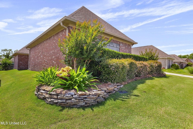 308 W Park St, Canton, MS 39046 - view of home's exterior with brick siding, a yard, and roof with shingles