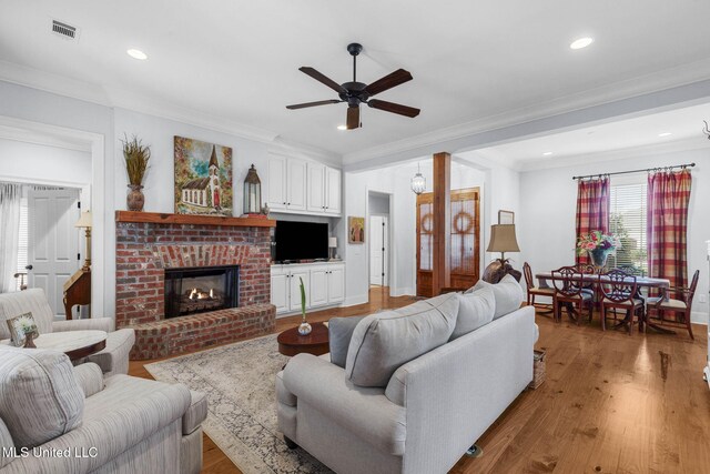 308 W Park St, Canton, MS 39046 - living room with a ceiling fan, light wood-style floors, ornamental molding, a fireplace, and baseboards