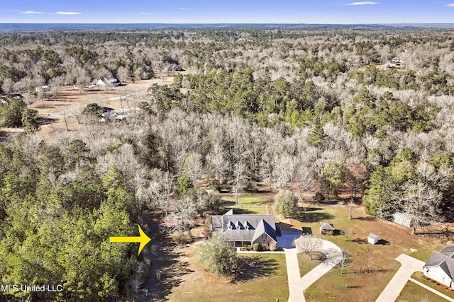 birds eye view of property featuring a view of trees