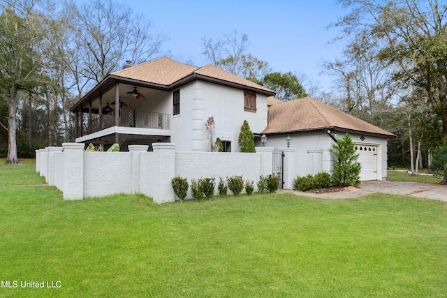 view of front facade featuring a garage, a balcony, ceiling fan, and a front yard