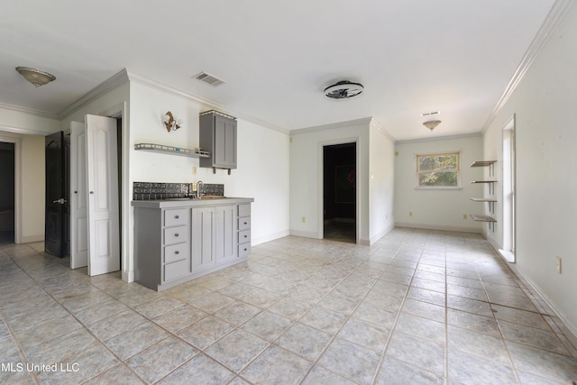 kitchen featuring sink, ornamental molding, gray cabinets, and light tile patterned floors