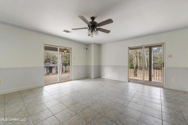 empty room with ceiling fan, light tile patterned floors, and crown molding