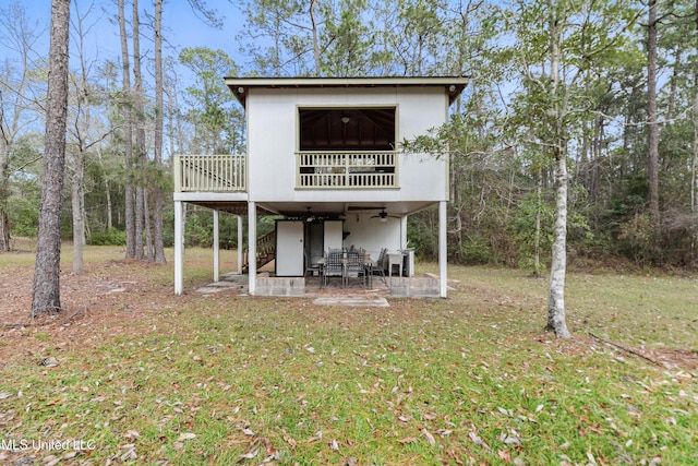 rear view of property featuring ceiling fan, a patio, a deck, and a yard