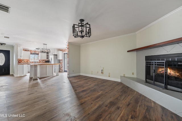 unfurnished living room with crown molding and dark hardwood / wood-style floors