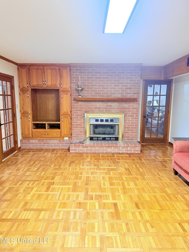 588 Robin Rd, Grenada, MS 38901 - unfurnished living room with light parquet floors, ornamental molding, a brick fireplace, and a skylight