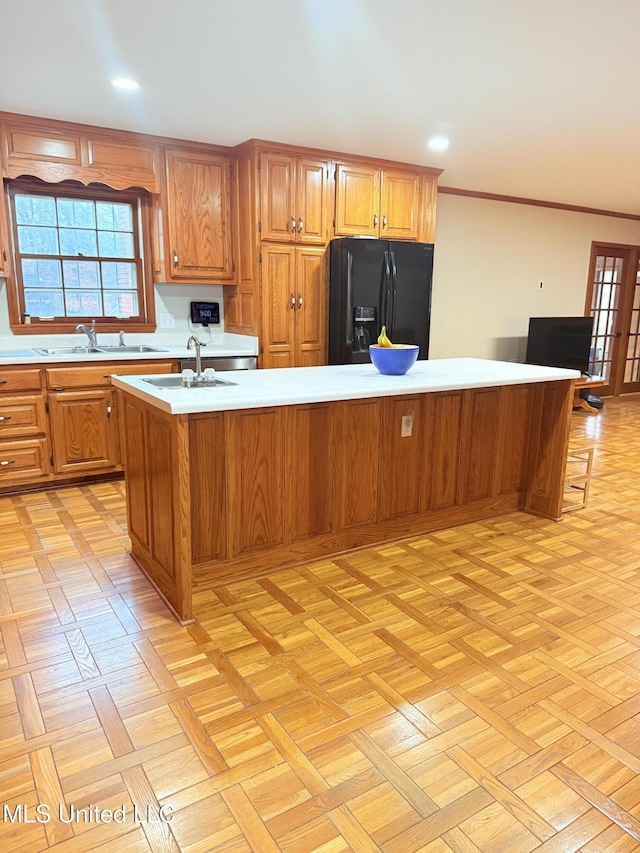 588 Robin Rd, Grenada, MS 38901 - kitchen with crown molding, black refrigerator with ice dispenser, an island with sink, and plenty of natural light