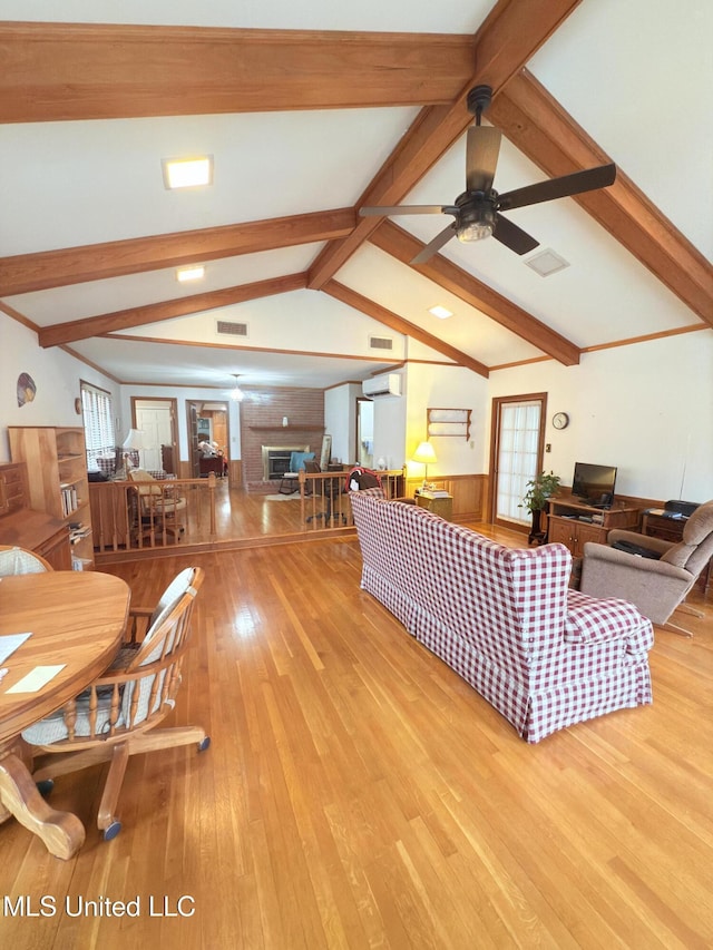 588 Robin Rd, Grenada, MS 38901 - living room with ceiling fan, a wall unit AC, lofted ceiling with beams, a brick fireplace, and light wood-type flooring