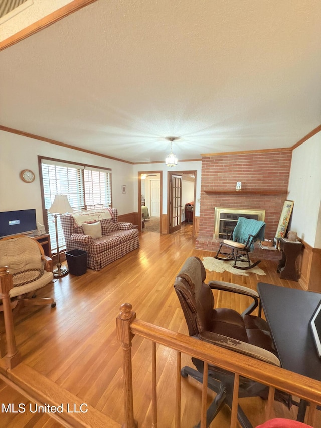588 Robin Rd, Grenada, MS 38901 - living room featuring crown molding, a brick fireplace, hardwood / wood-style floors, and a textured ceiling