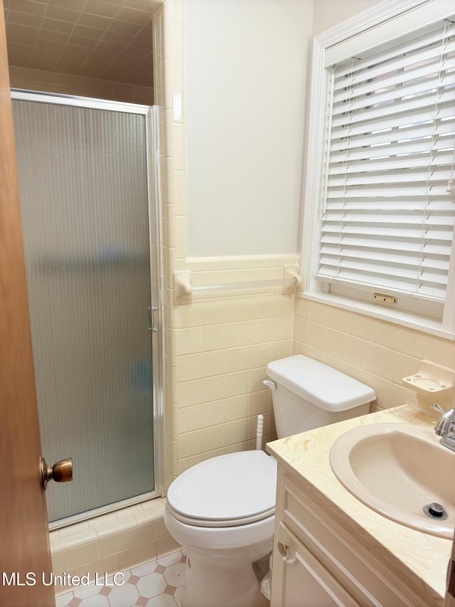 588 Robin Rd, Grenada, MS 38901 - bathroom featuring vanity, toilet, a shower with door, and tile walls