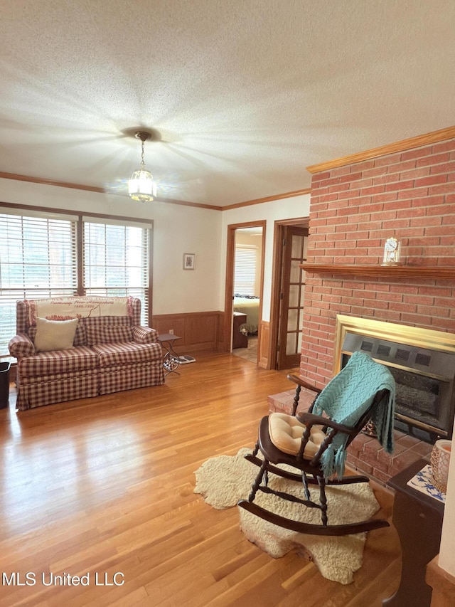 588 Robin Rd, Grenada, MS 38901 - living room featuring hardwood / wood-style flooring, a fireplace, ornamental molding, and a textured ceiling