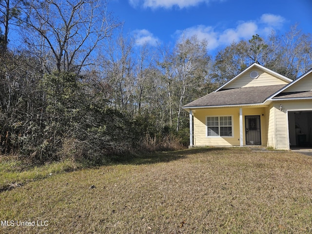 view of side of home with a yard