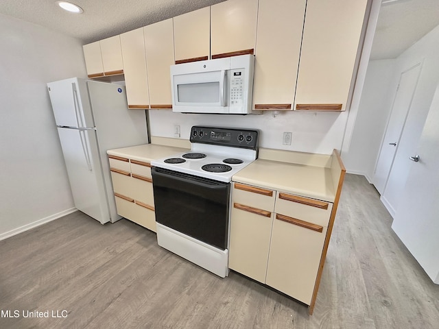 kitchen featuring light wood-type flooring, white appliances, baseboards, and light countertops