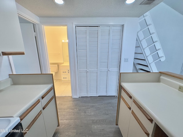 kitchen with white cabinetry, dark wood finished floors, a textured ceiling, and light countertops