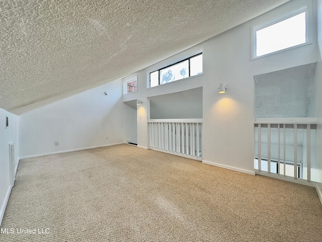 bonus room featuring a textured ceiling, carpet flooring, and baseboards