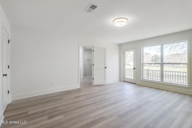 interior space with baseboards, visible vents, and light wood finished floors