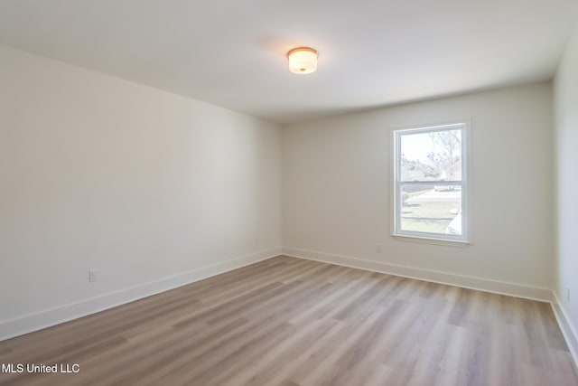 spare room with light wood-style flooring and baseboards