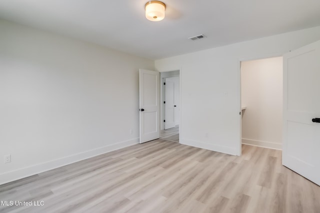 unfurnished bedroom featuring visible vents, baseboards, and light wood-style floors