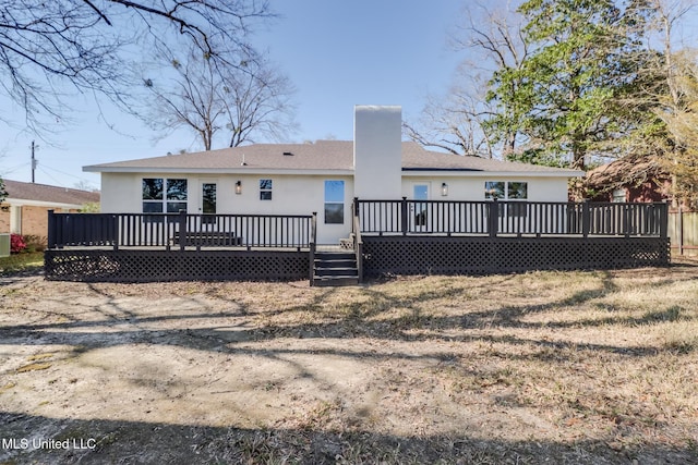 rear view of property featuring stucco siding, a chimney, and a deck