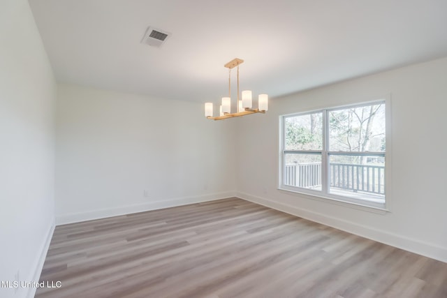 empty room featuring visible vents, baseboards, and light wood-style flooring