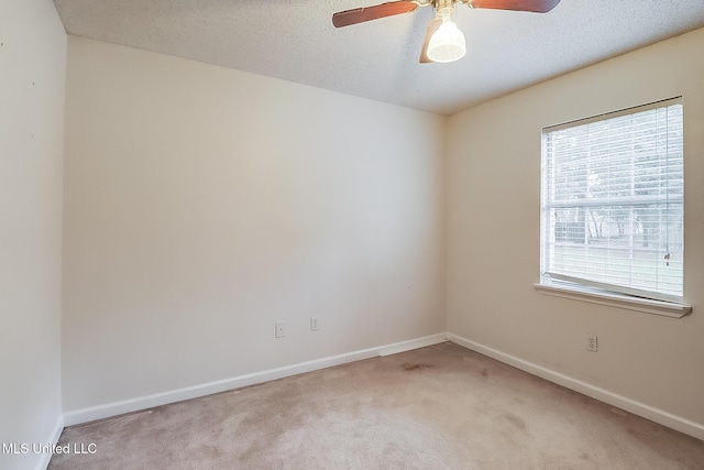 empty room featuring ceiling fan, plenty of natural light, a textured ceiling, and light carpet